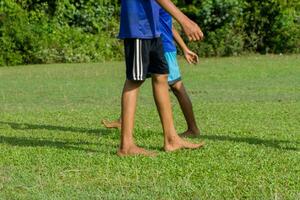 Treinamento sessão dentro futebol para juventude jogadoras. crianças jogando futebol dentro descalço foto