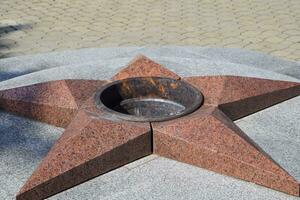 queimando do eterno fogo. cinco pontas Estrela fez do granito memorial para a memória do morto soldados foto