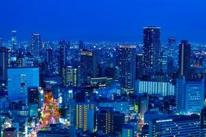 uma crepúsculo paisagem urbana de Alto ângulo Visão perto a escritório edifícios dentro Osaka foto