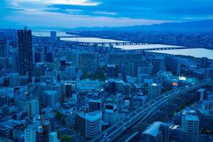 uma crepúsculo panorâmico paisagem urbana perto iodo rio dentro Osaka foto