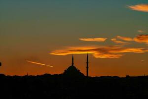 silhueta do fatih mesquita às pôr do sol. islâmico fundo foto