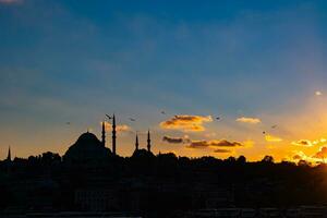 Istambul silhueta às pôr do sol. suleymaniye mesquita e nublado céu foto