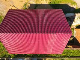 uma casa com uma vermelho cobertura fez do ondulado metal folhas. cobertura a partir de ondulado metal perfil. metal azulejos. foto
