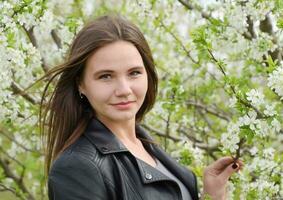 lindo fada jovem menina dentro uma floração ameixa jardim. retrato foto