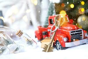 carro retrô vermelho com uma árvore de natal decora com a chave da casa na caminhonete para o natal. compra de uma casa, mudança, hipoteca, empréstimo, imóveis, clima festivo, ano novo foto