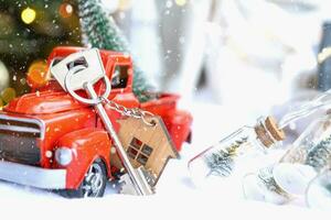 carro retrô vermelho com uma árvore de natal decora com a chave da casa na caminhonete para o natal. compra de uma casa, mudança, hipoteca, empréstimo, imóveis, clima festivo, ano novo foto