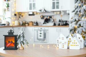 acolhedor Natal decoração minúsculo casa do pequeno Tamanho em mesa do festivo branco moderno cozinha. presente para Novo ano. seguro, comovente para Novo casa, hipoteca, renda e compra real Estado foto