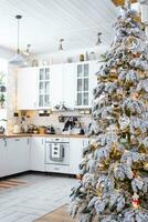 festivo Natal decoração dentro branco cozinha, moderno rústico interior com uma Nevado Natal árvore e fada luzes. Novo ano, Natal humor, acolhedor lar. a geral plano foto