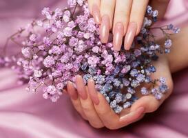 fêmea mãos com Rosa unha Projeto aguarde Gypsophila flores foto