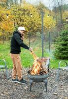 uma homem luzes uma churrasco dentro natureza foto