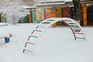 crianças Parque infantil dentro a cidade parque debaixo a neve dentro inverno. foto