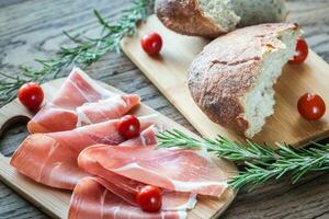 fatias de jamon na placa de madeira foto