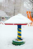 crianças Parque infantil coberto com neve dentro a parque depois de uma nevasca foto