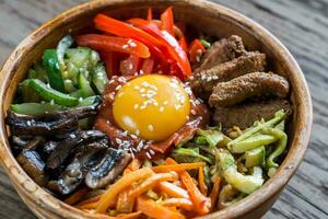 tigela do bibimbap em a de madeira mesa foto