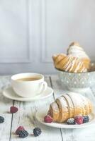 croissants com fresco bagas e uma copo do café foto