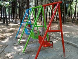 colorida balanços dentro a parque, balanço dentro a jardim, esvaziar balanços dentro a Parque infantil foto