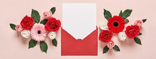 vermelho envelope com romântico amor carta brincar e flores em Rosa bandeira foto