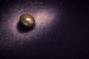 dourado ovo e pintura spray galáxia em roxa fundo. abstrato cosmos. feliz Páscoa conceito foto