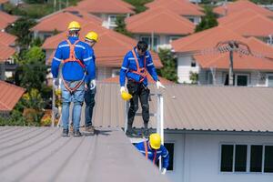 depois de instalando e inspecionando a desempenho do a solar célula painéis em a fábrica teto, uma grupo do engenheiros instalando solar painéis desce a escadas para ir casa foto