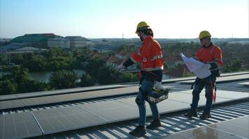 ambos do técnicos é instalando solar painéis em a cobertura do a armazém para mudança solar energia para dentro elétrico energia para usar dentro fábricas. foto