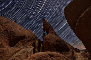 trilha noturna de estrelas percorre as rochas do parque joshua tree foto