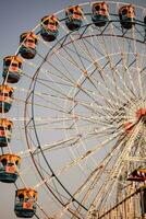 fechar-se do multicolorido gigante roda durante dussehra mela dentro Délhi, Índia. inferior Visão do gigante roda balanço. roda gigante com colorida cabines durante dia tempo. foto