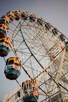 fechar-se do multicolorido gigante roda durante dussehra mela dentro Délhi, Índia. inferior Visão do gigante roda balanço. roda gigante com colorida cabines durante dia tempo. foto