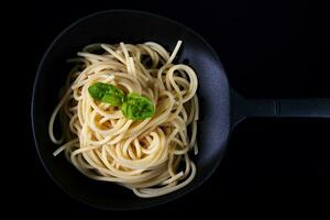 italiano espaguete com manjericão folhas cozinhou dentro uma escorredor de macarrão foto