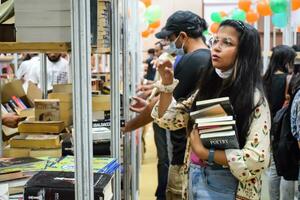 Délhi, Índia, setembro 09 2023 - vários era grupo pessoas lendo variedade do livros em estante dentro uma barraca de livros às Délhi internacional livro justo, seleção do livros em exibição dentro anual livro justo foto