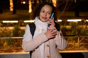 mulher usando telefone caminhando dentro a rua dentro Natal foto