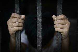 a criança capturado a ferro cela com tristeza e desespero. a conceito do parando violência contra crianças e humano tráfico. foto