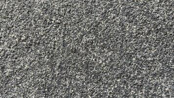 a superfície do a concreto parede é coberto com pequeno cinzento seixos. foto