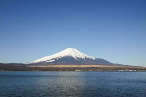 Fuji montanha Visão ao lado lago debaixo azul céu foto