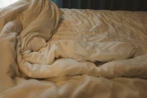 colchões cobertores e almofadas em a cama dentro a hotel. foto