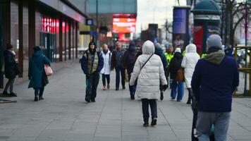 Varsóvia, Polônia. 29 dezembro 2023. pessoas do diferente idades e nacionalidades andar através dentro a cidade Centro, inverno tempo. pessoas às a rua. foto