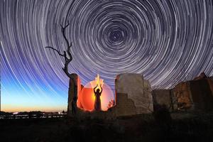 pessoa luz pintada no deserto sob o céu noturno foto