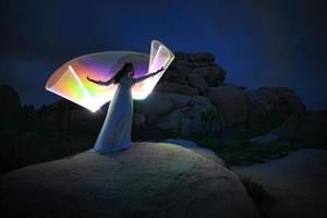 pessoa luz pintada no deserto sob o céu noturno foto