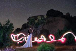 pessoa luz pintada no deserto sob o céu noturno foto