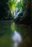 Visita a charme do Indonésia com a lorong watu cachoeira, norte bengkulu. uma limitar beco forrado com pedra paredes, a manhã luz brilha em a cascata foto