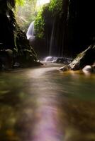 Visita a charme do Indonésia com a lorong watu cachoeira, norte bengkulu. uma limitar beco forrado com pedra paredes, a manhã luz brilha em a cascata foto