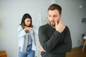 abusivo esposa discutindo marido, com ciumes desconfiado dominante mulher gritando às triste homem foto