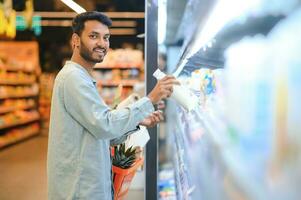 ásia homens estão escolhendo para Comprar dentro a supermercado foto