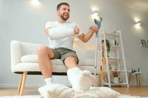 feliz homem recuperação a partir de acidente fratura quebrado osso prejuízo com perna e braço. social segurança e saúde seguro conceito foto