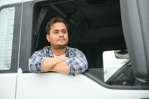 retrato do uma jovem bonito indiano caminhão motorista. a conceito do logística e frete transporte. foto