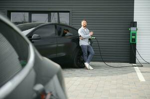 uma homem cobranças a elétrico carro foto