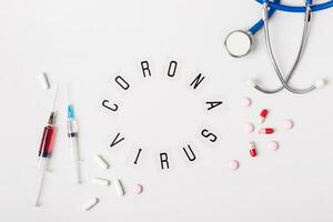 coronavírus tratamento conceito. vários pílulas, estetoscópio e seringas em cinzento fundo foto
