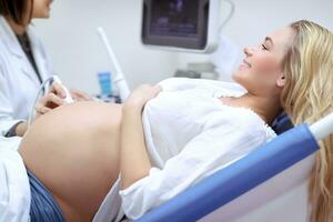 alegre grávida mulher em ultrassom foto