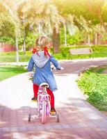pequeno menina em a bicicleta foto