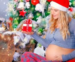 grávida mulher com Natal presente foto