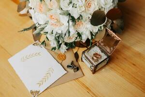 acessórios para a do noivo casamento. luxuoso ramalhete do a noivo. dourado Casamento convite, dourado argolas, abotoaduras em de madeira chão fundo. masculino moda foto